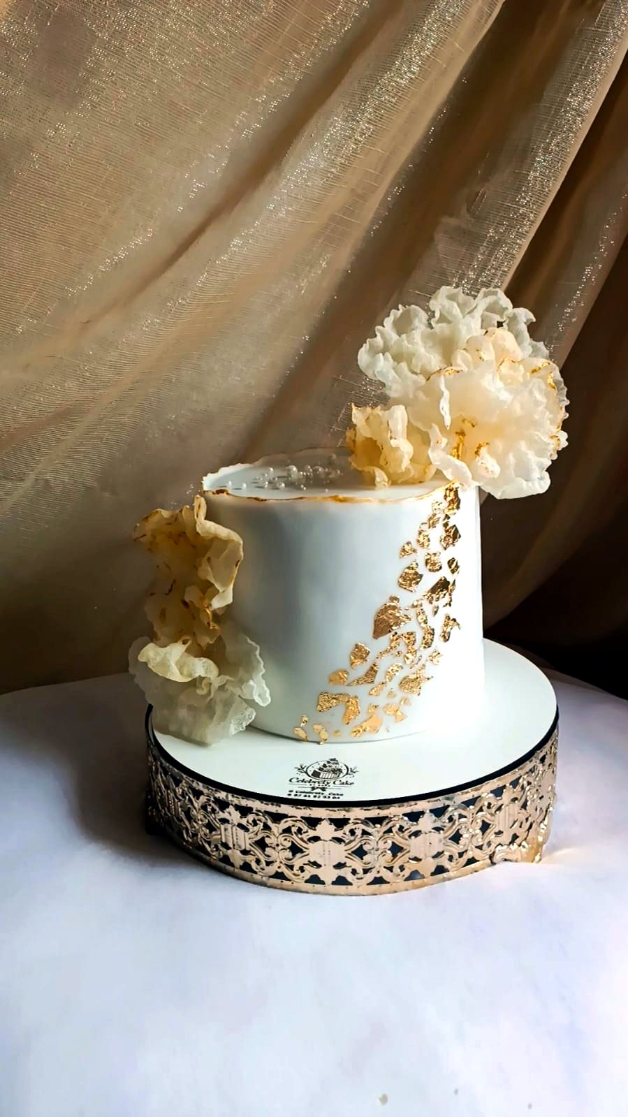 Cake design blanc et or avec cascade de fleurs